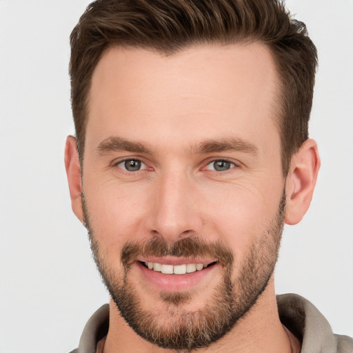 Joyful white young-adult male with short  brown hair and brown eyes