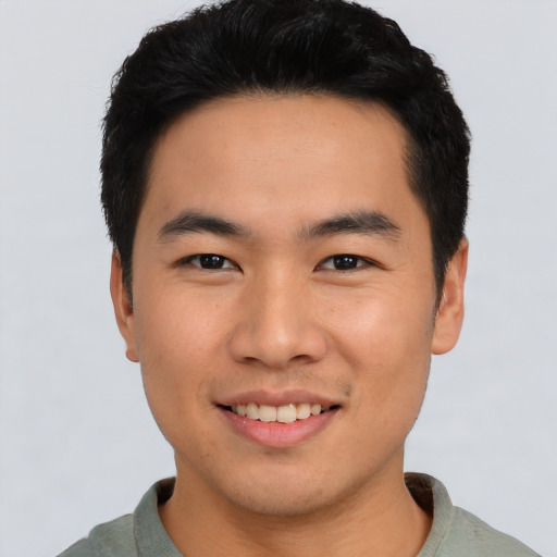 Joyful asian young-adult male with short  black hair and brown eyes