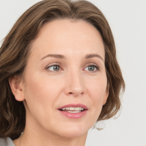 Joyful white adult female with medium  brown hair and green eyes