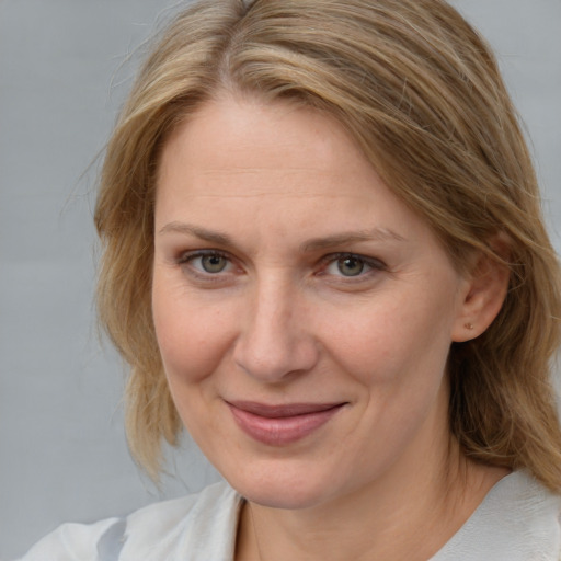 Joyful white adult female with medium  brown hair and blue eyes