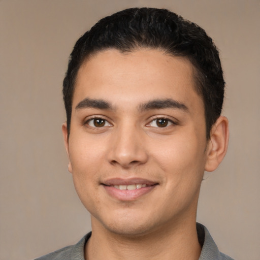 Joyful latino young-adult male with short  black hair and brown eyes