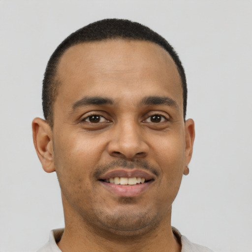 Joyful latino young-adult male with short  brown hair and brown eyes