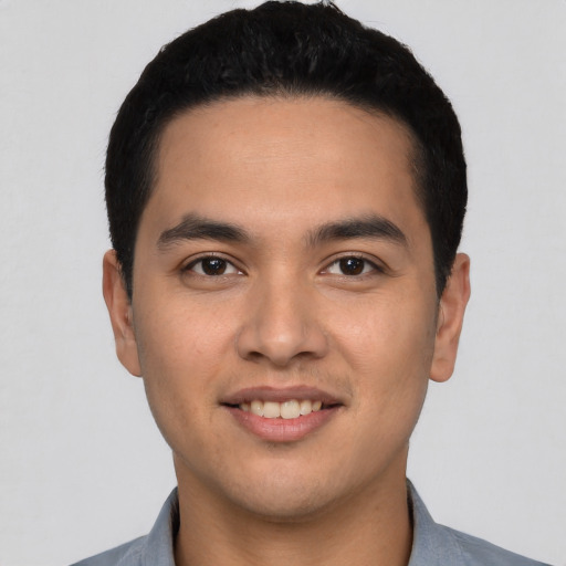 Joyful latino young-adult male with short  black hair and brown eyes