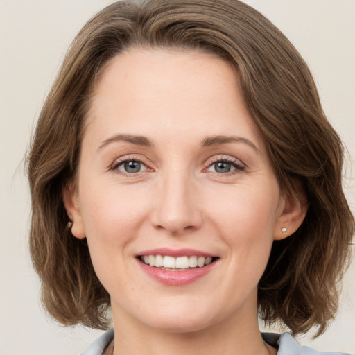 Joyful white young-adult female with medium  brown hair and green eyes