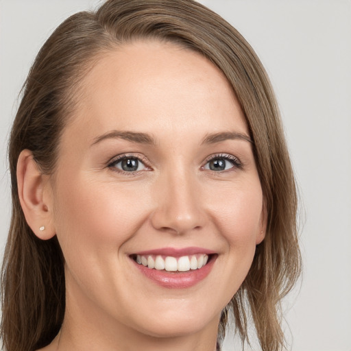 Joyful white young-adult female with long  brown hair and grey eyes