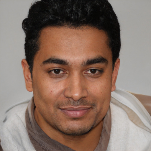 Joyful latino young-adult male with short  black hair and brown eyes