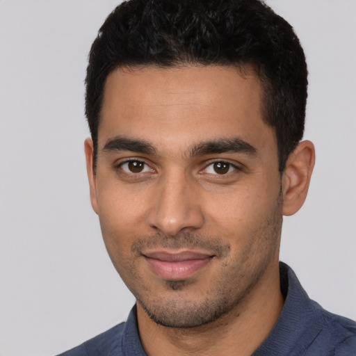 Joyful latino young-adult male with short  brown hair and brown eyes