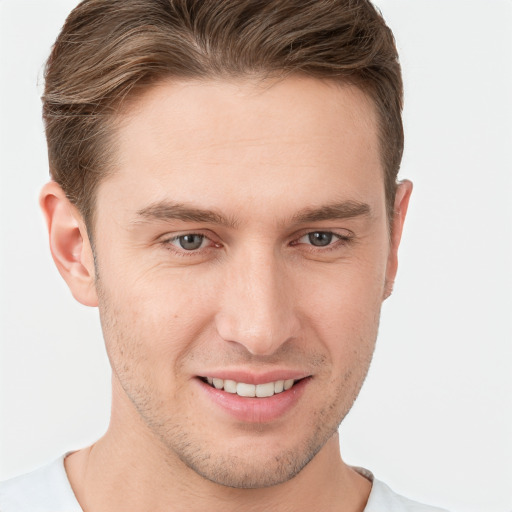 Joyful white young-adult male with short  brown hair and grey eyes