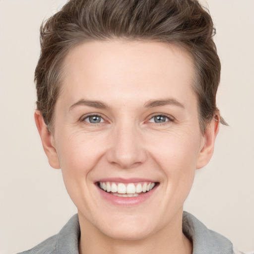 Joyful white young-adult female with short  brown hair and grey eyes