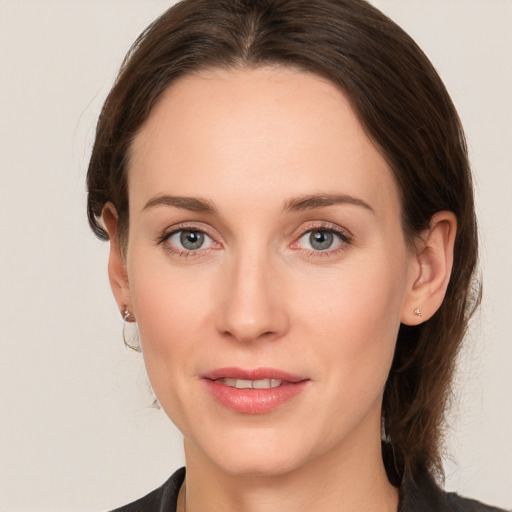 Joyful white young-adult female with medium  brown hair and grey eyes