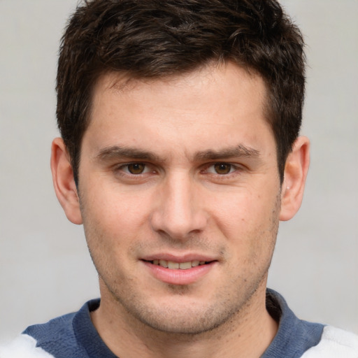 Joyful white young-adult male with short  brown hair and grey eyes