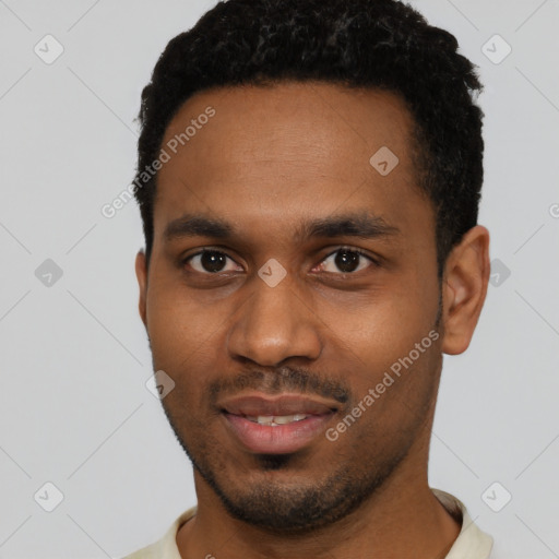 Joyful black young-adult male with short  black hair and brown eyes