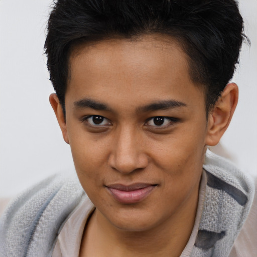 Joyful latino young-adult male with short  brown hair and brown eyes