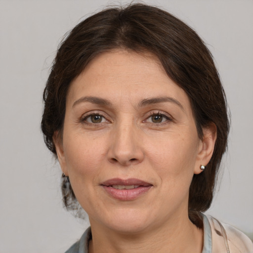 Joyful white adult female with medium  brown hair and brown eyes