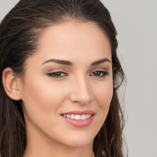 Joyful white young-adult female with long  brown hair and brown eyes