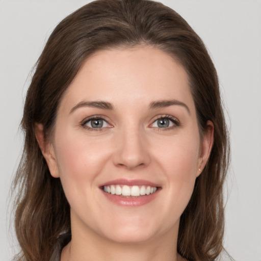 Joyful white young-adult female with medium  brown hair and grey eyes