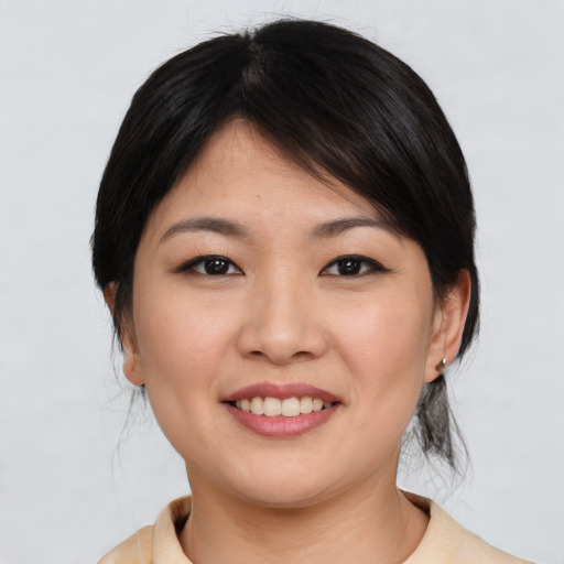 Joyful asian young-adult female with medium  brown hair and brown eyes
