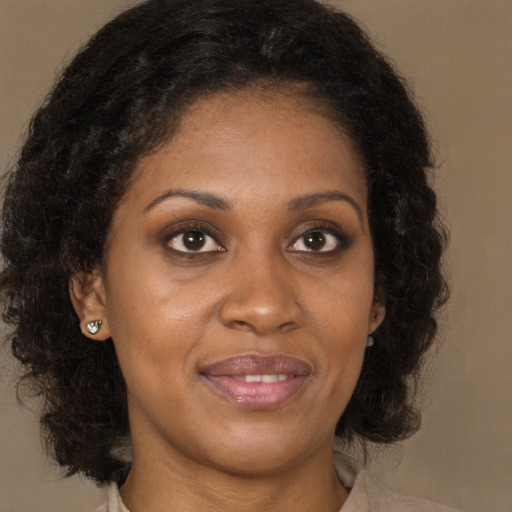 Joyful black young-adult female with medium  brown hair and brown eyes