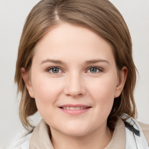 Joyful white young-adult female with medium  brown hair and grey eyes