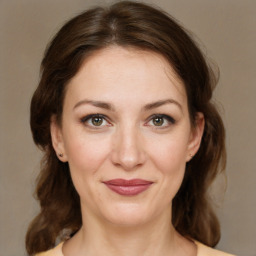 Joyful white young-adult female with medium  brown hair and green eyes