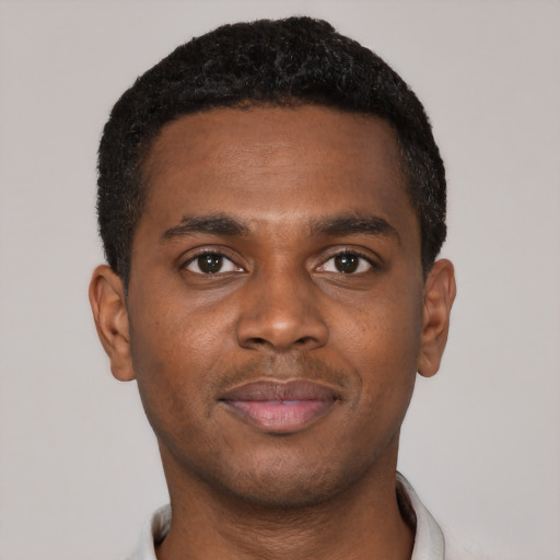 Joyful black young-adult male with short  black hair and brown eyes