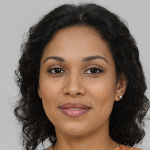 Joyful latino adult female with long  brown hair and brown eyes