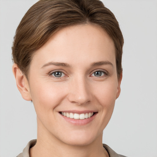 Joyful white young-adult female with short  brown hair and grey eyes