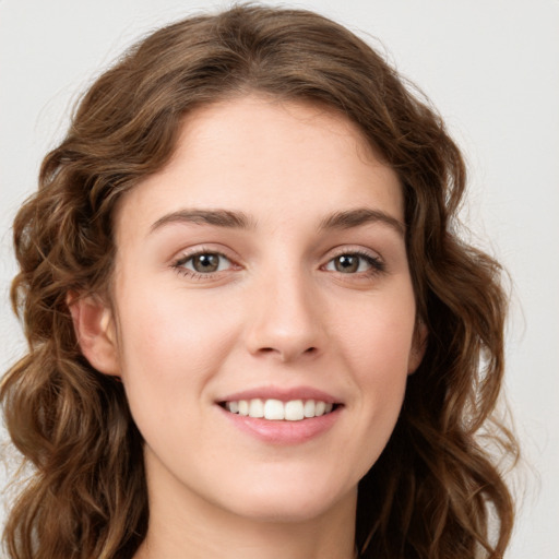 Joyful white young-adult female with long  brown hair and green eyes