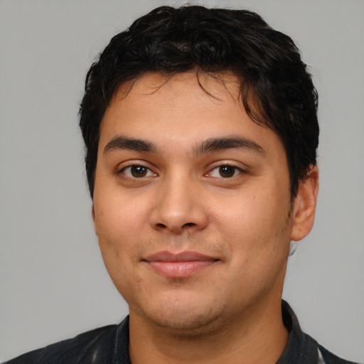 Joyful latino young-adult male with short  black hair and brown eyes