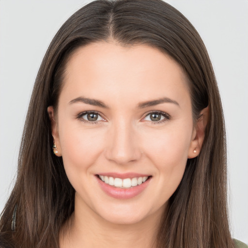 Joyful white young-adult female with long  brown hair and brown eyes