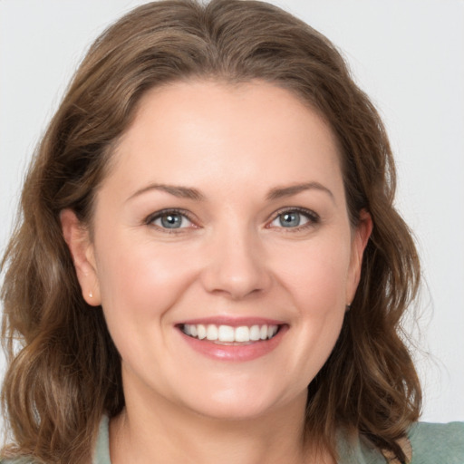 Joyful white young-adult female with medium  brown hair and grey eyes