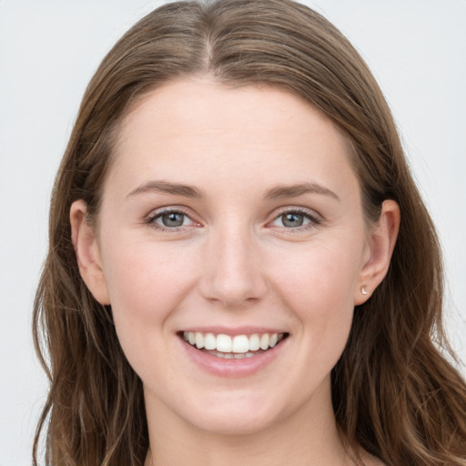 Joyful white young-adult female with long  brown hair and blue eyes