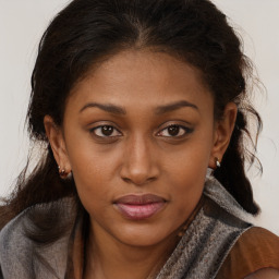 Joyful black young-adult female with long  brown hair and brown eyes