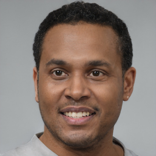 Joyful black young-adult male with short  black hair and brown eyes