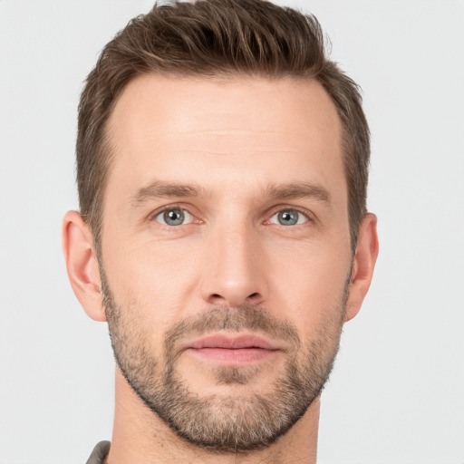 Joyful white young-adult male with short  brown hair and grey eyes