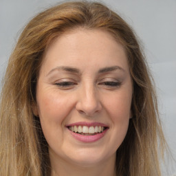 Joyful white adult female with long  brown hair and brown eyes