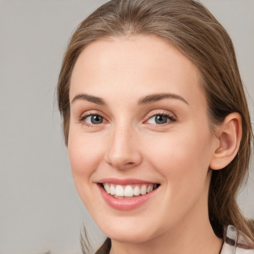 Joyful white young-adult female with medium  brown hair and blue eyes