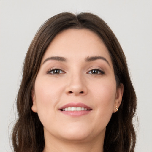 Joyful white young-adult female with long  brown hair and grey eyes