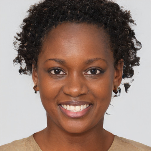 Joyful black young-adult female with short  brown hair and brown eyes