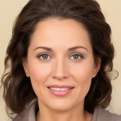 Joyful white adult female with long  brown hair and brown eyes