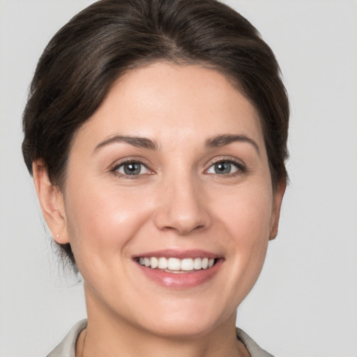 Joyful white young-adult female with short  brown hair and grey eyes