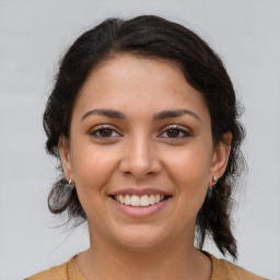 Joyful latino young-adult female with medium  brown hair and brown eyes