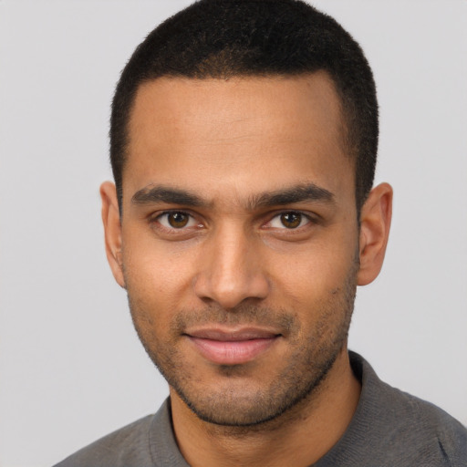 Joyful black young-adult male with short  brown hair and brown eyes