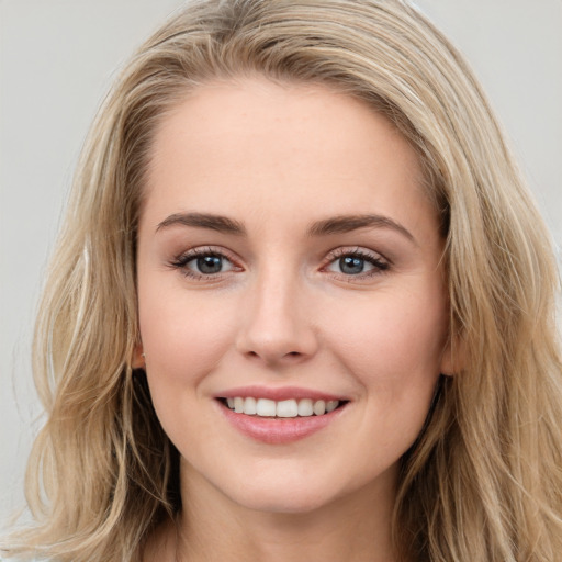 Joyful white young-adult female with long  brown hair and blue eyes