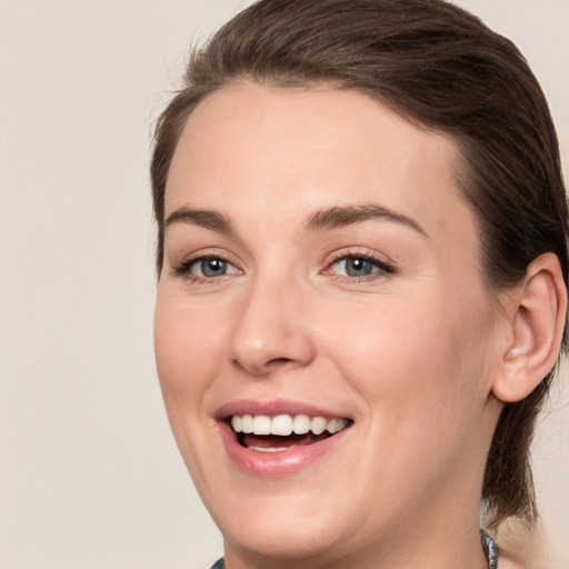 Joyful white young-adult female with medium  brown hair and grey eyes