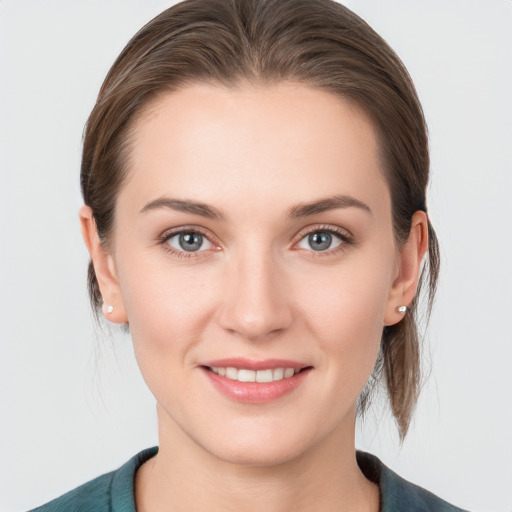 Joyful white young-adult female with medium  brown hair and grey eyes