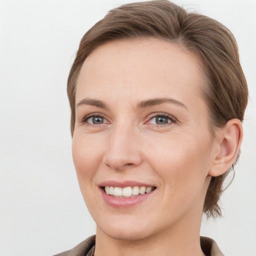 Joyful white young-adult female with short  brown hair and grey eyes