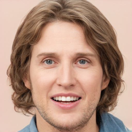 Joyful white young-adult male with medium  brown hair and blue eyes