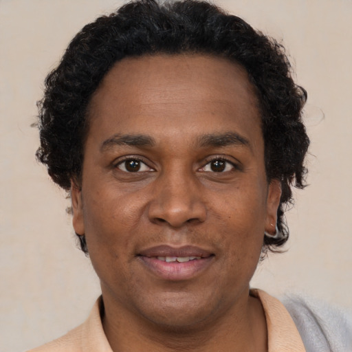 Joyful black adult male with short  brown hair and brown eyes