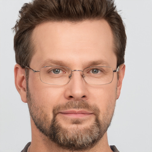 Joyful white adult male with short  brown hair and grey eyes